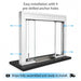 Clear Anodized Aluminum Frame with Glass Baffled Transaction Window with Base and Deal tray window system on a black base, shown on a white background with text reading 'Easy installation with 4 pre-drilled anchor holes' and blue arrows indicating direction. A shipping icon and text at the bottom say it ships fully assembled and ready to install.